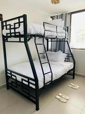 two bunk beds in a room with sandals on the floor at Imbasa House in Arusha