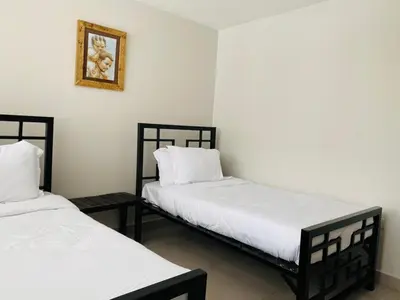 two beds sitting next to each other in a room at Imbasa House in Arusha