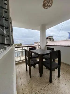 a table and chairs on a balcony with a view at Imbasa House in Arusha