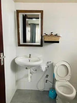 a bathroom with a sink and a toilet and a mirror at Imbasa House in Arusha