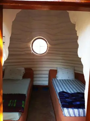 two beds in a small room with a window at Panorama Safari Camp in Mto wa Mbu