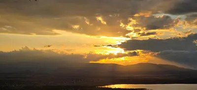 a sunset with the sun shining through the clouds at Panorama Safari Camp in Mto wa Mbu