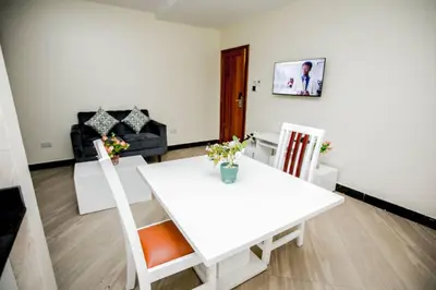 a living room with a white table and chairs at Snow View Rau Apartments in Moshi