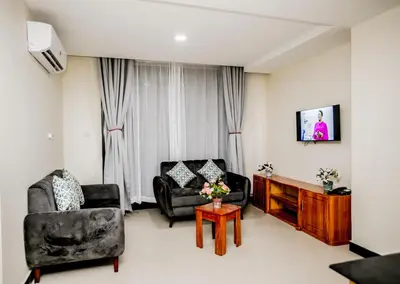 a living room with two chairs and a table at Snow View Rau Apartments in Moshi