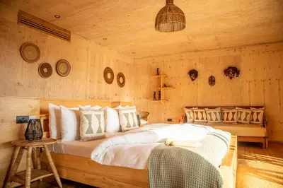 a bedroom with a large bed in a wooden wall at Rhotia Valley Tented camp in Karatu