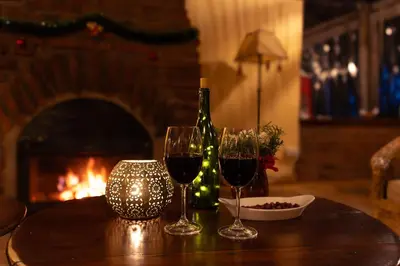 a table with two wine glasses and a bottle of wine at Rhotia Valley Tented camp in Karatu