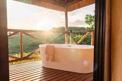 a bath tub sitting on a deck with a window at Rhotia Valley Tented camp in Karatu