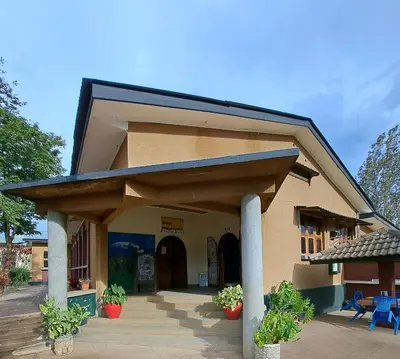 a building with a porch with potted plants at The Meserani Oasis Lodge in Arusha