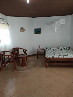 a room with two chairs and a bed and a table at The Meserani Oasis Lodge in Arusha