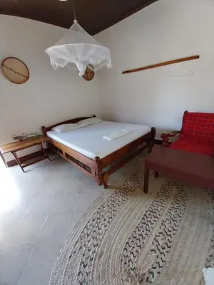 a bedroom with a bed and a red chair at The Meserani Oasis Lodge in Arusha