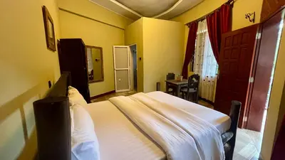 a small bedroom with two beds and a table at Skill forest lodge in Arusha