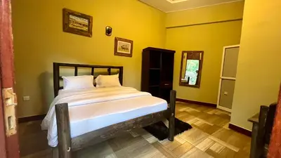 a bedroom with a bed in a room with yellow walls at Skill forest lodge in Arusha