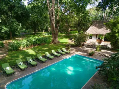 an overhead view of a swimming pool with chairs and a house at Rivertrees Country Inn in Usa River