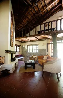 a living room with two couches and a table at Rivertrees Country Inn in Usa River