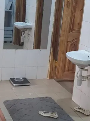 a bathroom with a sink and a mirror and a slippers at Sinana country Home-Backpackers Stay in Kibongoto