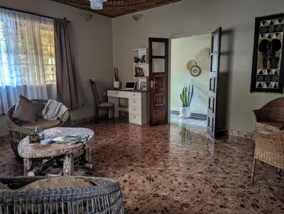 a living room with a table and a desk at The Lion King Homestay in Moshi