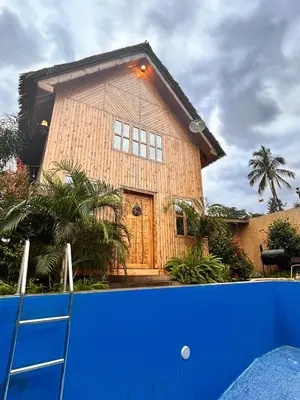 a wooden house with a blue fence in front of it at THE WOODEN HOUSE in Msaranga