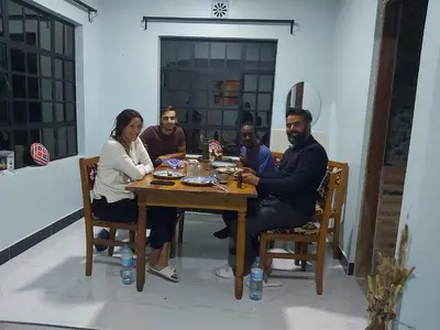 a group of people sitting around a wooden table at Mama Aziz Homestay in Arusha
