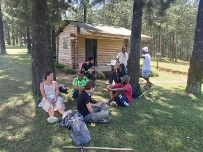 a group of people sitting in front of a cabin at Mama Aziz Homestay in Arusha