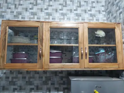 a wooden cabinet with dishes in it in a kitchen at Mama Aziz Homestay in Arusha