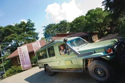 a woman is driving a green jeep at Dik Dik Hotel in Arusha