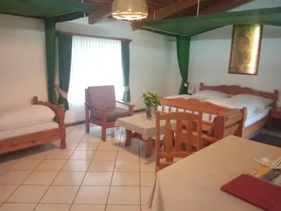 a room with two beds and a table and chairs at Dik Dik Hotel in Arusha