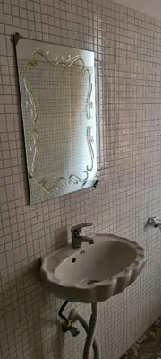 a white sink in a bathroom with a mirror at Triple D's in Moshi