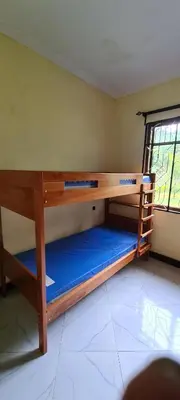 a bedroom with bunk beds in a room with a window at Triple D's in Moshi