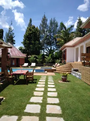 a garden with a table and chairs and a pool at Sprunger Avenue - tulia homes in Moshi