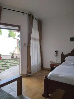 a bedroom with a bed and a sliding glass door at Sprunger Avenue - tulia homes in Moshi