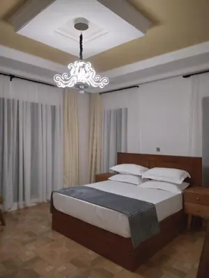 a bedroom with a large bed and a chandelier at Sprunger Avenue - tulia homes in Moshi