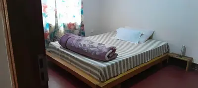 a small bed with a blanket on top of it at mamacollins homestay in Arusha