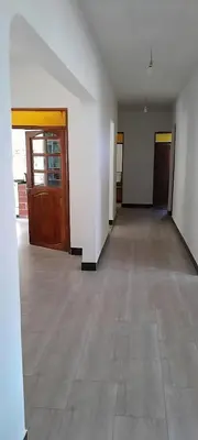 an empty room with two doors and a tile floor at mamacollins homestay in Arusha