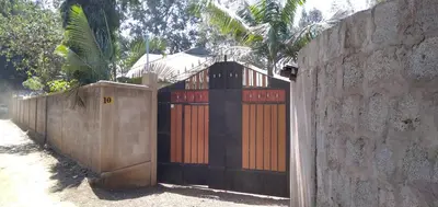 a fence with an orange door and a wall at mamacollins homestay in Arusha