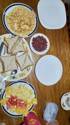 a wooden table with plates of food on it at mamacollins homestay in Arusha