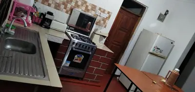 a small kitchen with a stove and a microwave at mamacollins homestay in Arusha