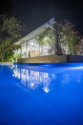 a building with a pool of water at night at Kilimanjaro Twin Rooms Queen Beds in Moshi