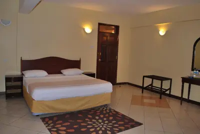 a hotel room with a bed and a mirror at Parkview Inn in Moshi