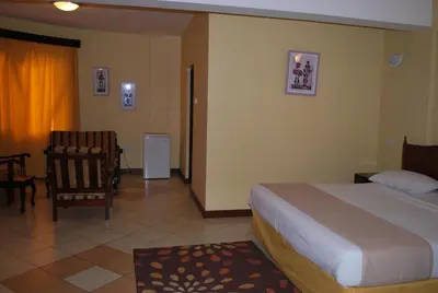 a hotel room with a bed and a chair at Parkview Inn in Moshi