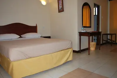 a bedroom with a bed and a table and a desk at Parkview Inn in Moshi