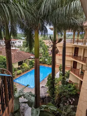 a view of the pool from the balcony of a hotel with palm trees at Parkview Inn in Moshi