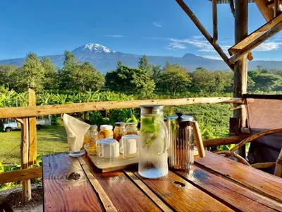 a wooden table with bottles on it with a view at Mount Kilimanjaro 360 view Cottage in Uru