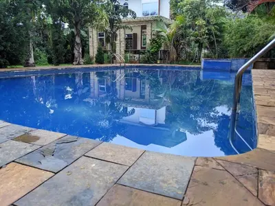 a swimming pool with blue water in front of a house at Mama Africa Killi Villa in Moshi