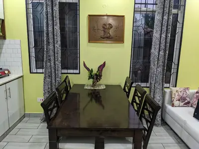 a dining room with a table and a couch at Mama Africa Killi Villa in Moshi