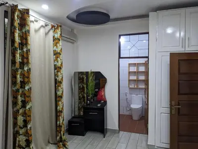a bathroom with a toilet and a shower curtain at Mama Africa Killi Villa in Moshi