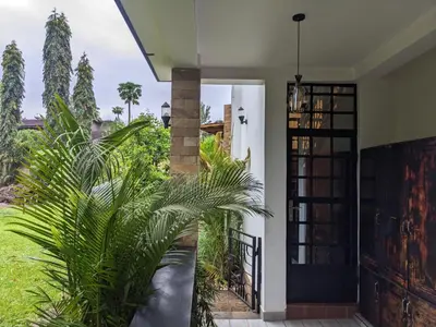 a house with a palm tree in front of a door at Mama Africa Killi Villa in Moshi