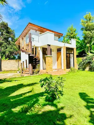 a house with a green lawn in front of it at Golden hour tiny house in Arusha