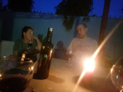 a man and a woman sitting at a table with wine bottles at Ngorongoro Villa and Restaurant in Karatu