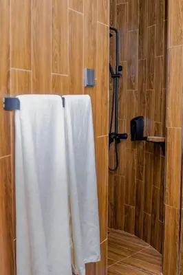 a bathroom with a shower with a white towel at Tulivu Kilimanjaro Retreat in Moshi