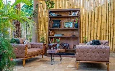 a living room with two couches and a book shelf at Tulivu Kilimanjaro Retreat in Moshi